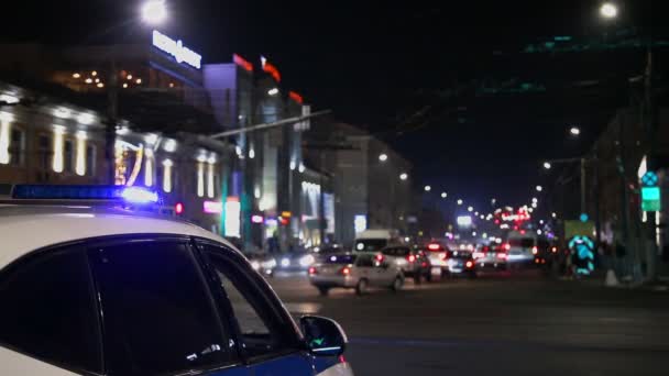 警察の車のライトが夜市で点滅選択的フォーカスとボケ — ストック動画