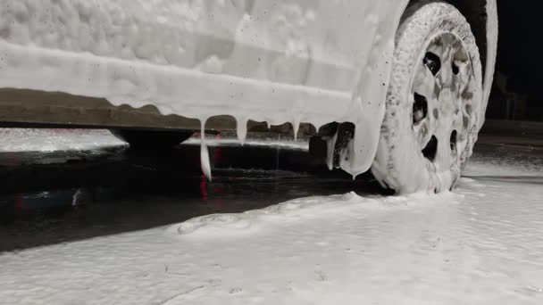 Biały mydło sud spada z drzwi samochodu podczas mycia samochodu w nocy w stacji publicznej — Wideo stockowe