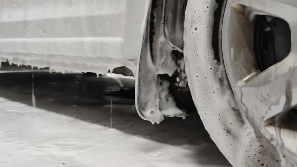 Biały mydło sud spada z drzwi samochodu podczas mycia samochodu w nocy w stacji publicznej — Wideo stockowe