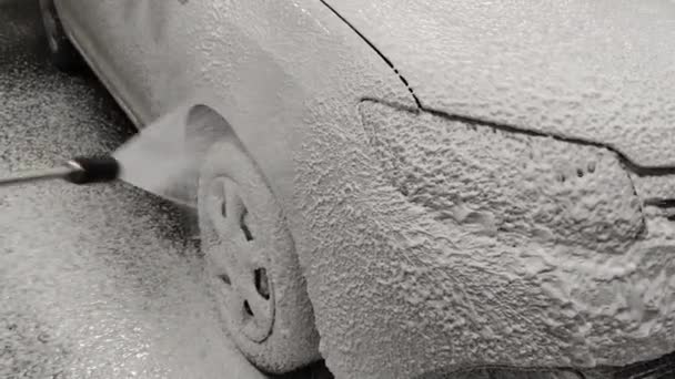 Hand covering car with soap sud detergent at night outdoor self-service car wash — Stock Video