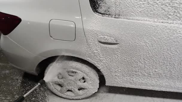 Handbekleding auto met zeep sud wasmiddel 's nachts buiten self-service car wash — Stockvideo