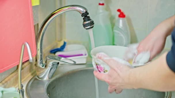 Homem branco nu lavar pratos com detergente de sabão líquido e esponja azul-amarela — Vídeo de Stock