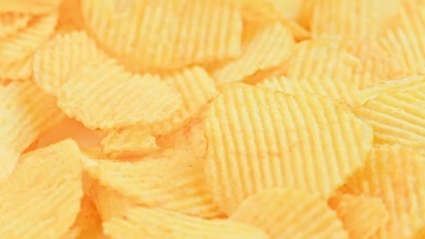 Loopas spinning gul vågig potatis chips full ram närbild bakgrund — Stockvideo