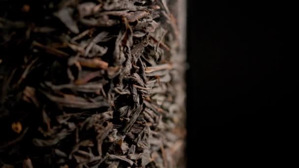 Schleife Spinnen trockener schwarzer Tee innerhalb Glassäule Nahaufnahme Hintergrund — Stockvideo