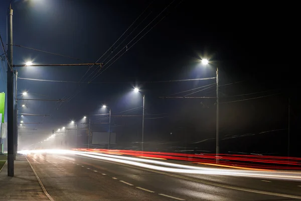 Lege mistige nacht weg met rijen van lantaarnpalen — Stockfoto