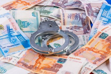 Rus kağıt rublesi üzerine gümüş renkli kelepçe para birimi arka planı - Rus mali suç kavramı