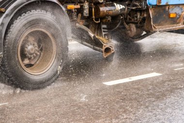 Yağmurlu bir günde asfalt yolda ilerleyen eski bir kamu kamyonu. Yakın plan..