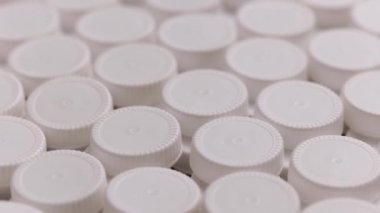 Beyaz yüksek yoğunluklu polietilen plastik kapakların yakın plan dönen döngüsü.