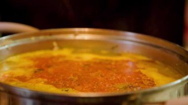 Beyaz el sıcak pirinç köftesi çorbasını kaşıkla karıştırıyor- seçici bir odaklanma ile yavaşlatılıyor