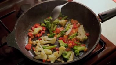 Kafkas el kızartma tavasında sebzeleri karıştırırken kızarırken paslanmaz çelik kaşık, yakın çekim yavaş çekim.