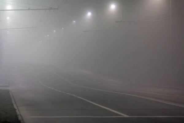 空旷的雾蒙蒙的夜路 有一排灯柱 — 图库照片