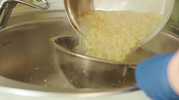 Ruce Modrých Rukavicích Vypouštění Horké Těstoviny Přes Kolant Nad Kuchyňským — Stock video