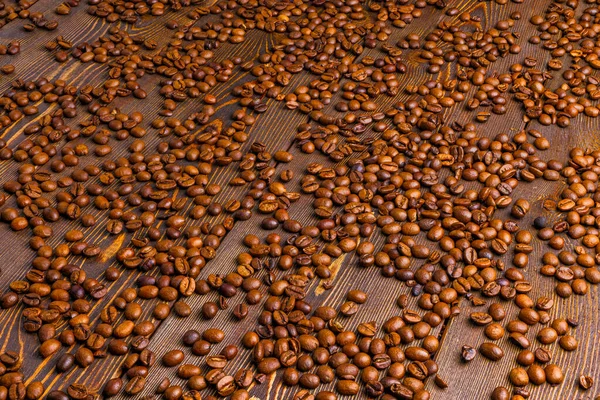 Roasted coffe beans spreaded over wooden board - full frame background — Stock Photo, Image