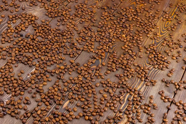 Roasted coffe beans spreaded over wooden board - full frame background — Stock Photo, Image