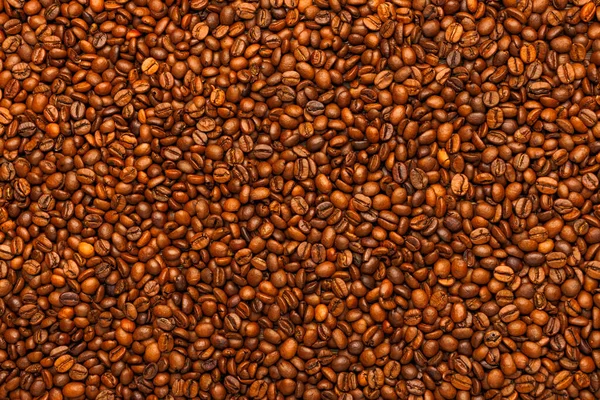 Full frame background and texture of roasted coffee beans on flat wooden surface — Stock Photo, Image