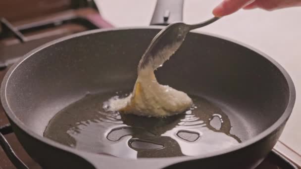 Pone a mano masa semilíquida en una sartén precalentada cubierta con aceite vegetal — Vídeo de stock
