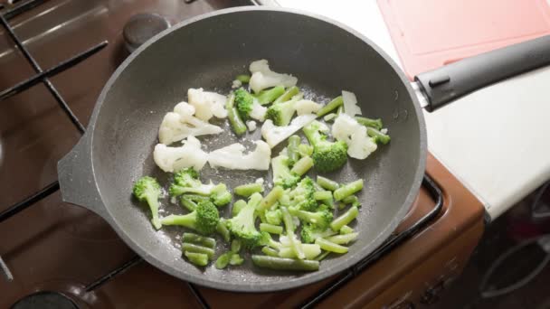 Cámara lenta primer plano de freír verduras en la sartén con salpicaduras sin tapa — Vídeo de stock