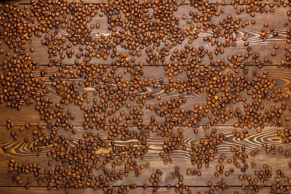 木の板の上に広がるローストコーヒー豆-フルフレームの背景、高い角度のビュー — ストック写真