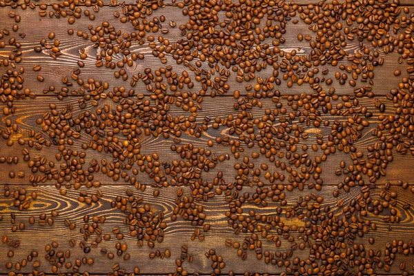 Καβουρδισμένοι κόκκοι καφέ με σπείρωμα πάνω από ξύλινη σανίδα - full frame background, προβολή υψηλής γωνίας — Φωτογραφία Αρχείου