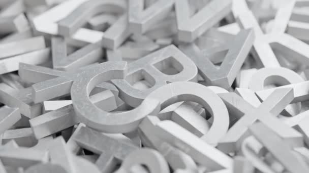 Full frame close-up looped slowly rotating background of silver metal letters with selective focus — Stock Video