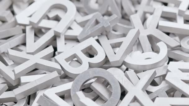 Full frame close-up looped slowly rotating background of silver metal letters with selective focus — Stock Video