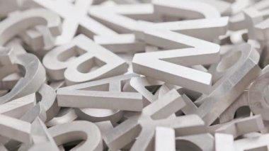 tam kare yakın döngü, seçici odaklı gümüş metal harflerin yavaşça dönen arkaplanı