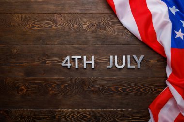 4 Temmuz ve buruşuk ABD bayrağı düz desenli ahşap yüzey arka planında