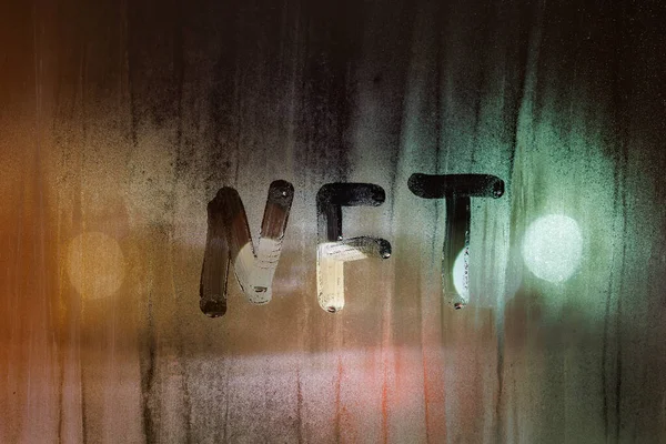 NFTという言葉-夜に窓ガラスに手書きされたファンタブルトークン — ストック写真