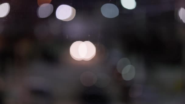 Крупним планом нічне скло з розблокованими автомобільними ліхтарями та вуличними ліхтарями — стокове відео