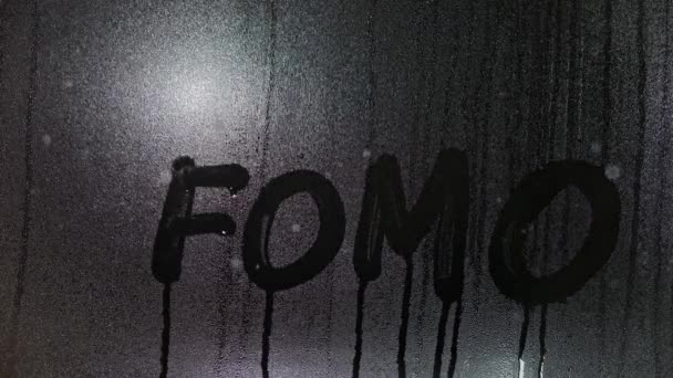 फ़ोमो शब्द रात में धुंधली खिड़की ग्लास पर हस्तलिखित याद करने का डर — स्टॉक वीडियो