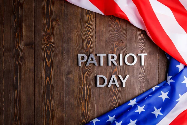 Las palabras patriota día establecido con letras de metal de plata en la superficie de madera con la bandera de EE.UU. arrugado —  Fotos de Stock