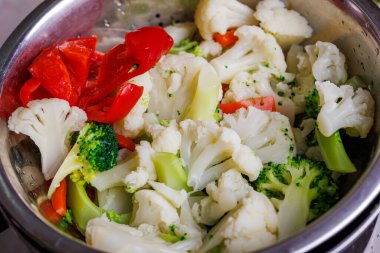 Doğranmış haşlanmış sebzeler kevgire yakın çekim, tam çerçeve arka plan