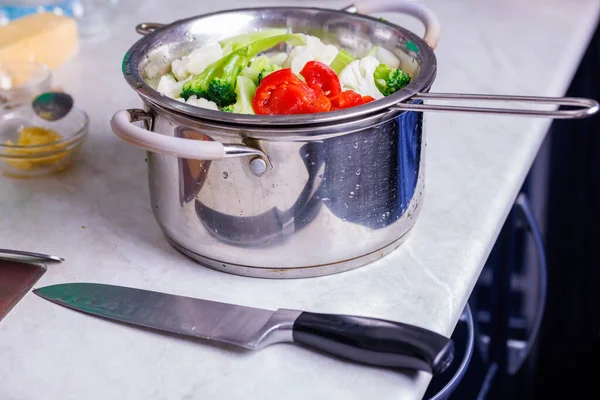 chopped boiled vegetables in colander in stainless steel cooking pot close-up