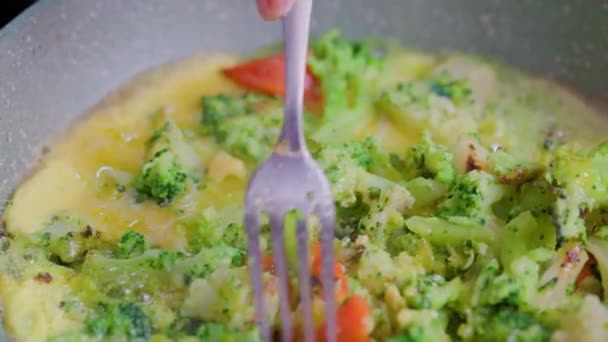 Рука с вилкой выбирает жарить овощи с яичным желтком крупным планом — стоковое видео