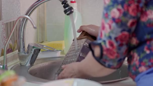 Idős kaukázusi nő mosogatás ételek sárga szivacs a konyhában — Stock videók