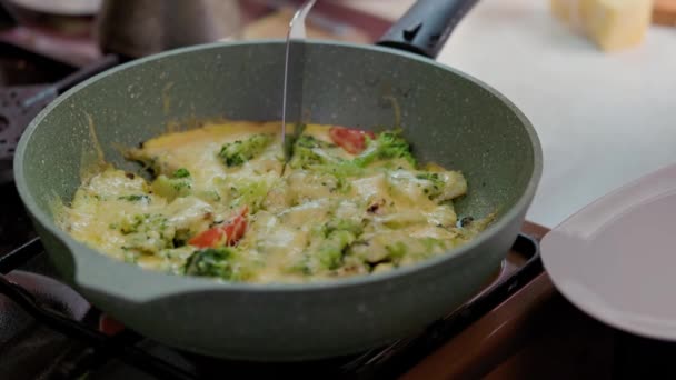 Hand med spatel skivning omelett med färska grönsaker — Stockvideo
