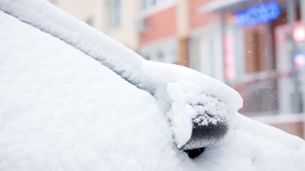 Detailní pohled na zasněžené auto za zimního dne sněžení, pomalé — Stock video