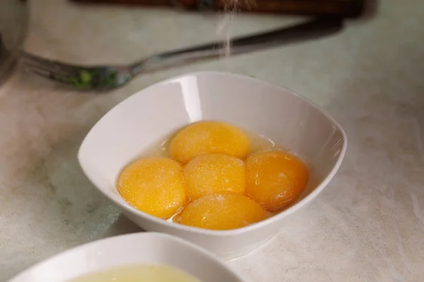 Salted five raw chicken egg yolks in a white ceramic bowl — Fotografia de Stock