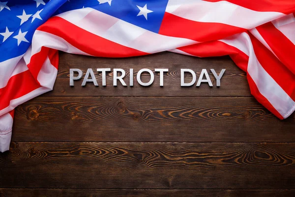 Orden patriot dag läggs med silver metall bokstäver på träskiva yta med skrynklig usa flagga — Stockfoto