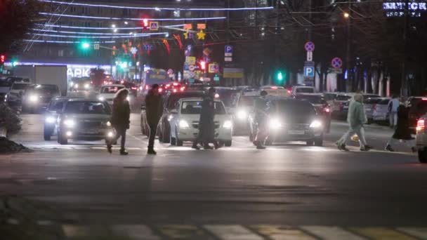 Fußgänger überqueren in der Winternacht zentrale Straße — Stockvideo