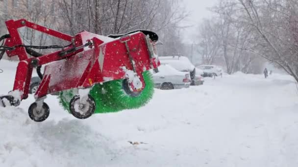 Parou arado de neve verde no fundo de um parque de estacionamento nevado durante o dia durante a queda de neve pesada em câmera lenta — Vídeo de Stock