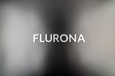 Flurona kelimesi parlak siyah arkaplanda gümüş metal harflerle yazılıydı.