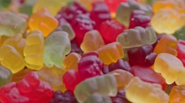 full frame looped spinning background of colorful jelly bear candies heap