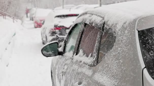Fila de carros estacionados à luz do dia nevasca - close-up em câmera lenta — Vídeo de Stock