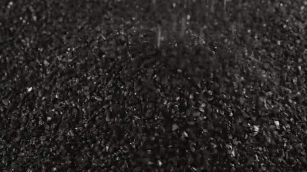 Aspersión de carbón de coco negro primer plano slo-mo, fracción pequeña de carbón activado — Vídeo de stock