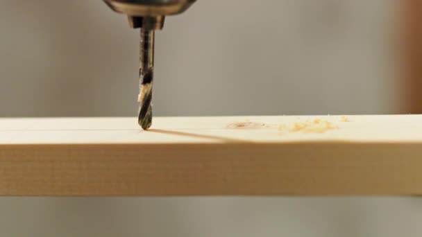 Taladro de giro taladros a través de una tabla de madera de primer plano en slo-mo — Vídeo de stock