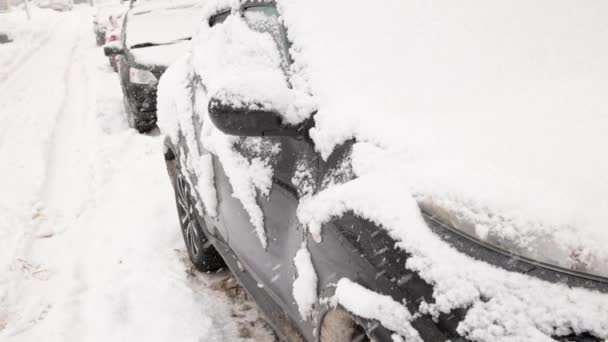 Σειρά από σταθμευμένα αυτοκίνητα στο φως της ημέρας χιονοθύελλα - close-up σε αργή κίνηση — Αρχείο Βίντεο