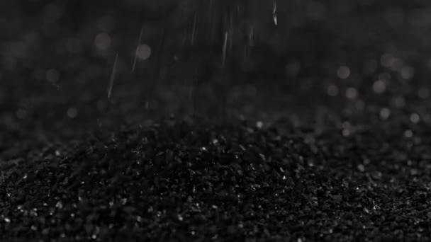 Aspersión de carbón de coco negro primer plano slo-mo, fracción pequeña de carbón activado — Vídeos de Stock