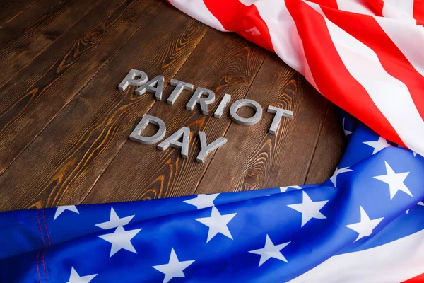 Orden patriot dag läggs med silver metall bokstäver på träskiva yta med skrynklig usa flagga — Stockfoto