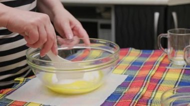 Beyaz plastik spatulayla şeker ve sıvı hamuru karıştıran yaşlı beyaz kadın.